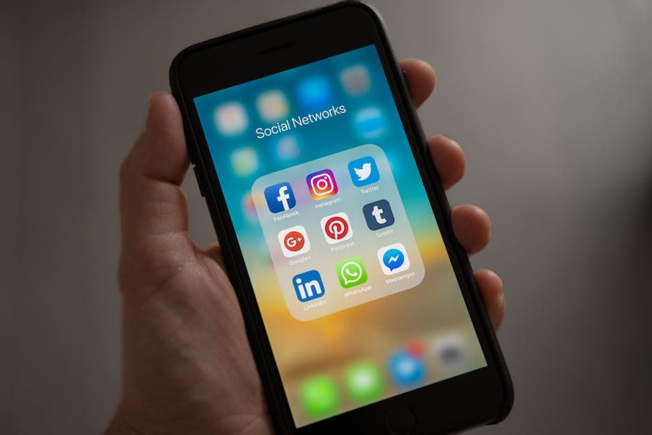 Persoon die een iPhone vasthoudt met de map Sociale netwerken zichtbaar