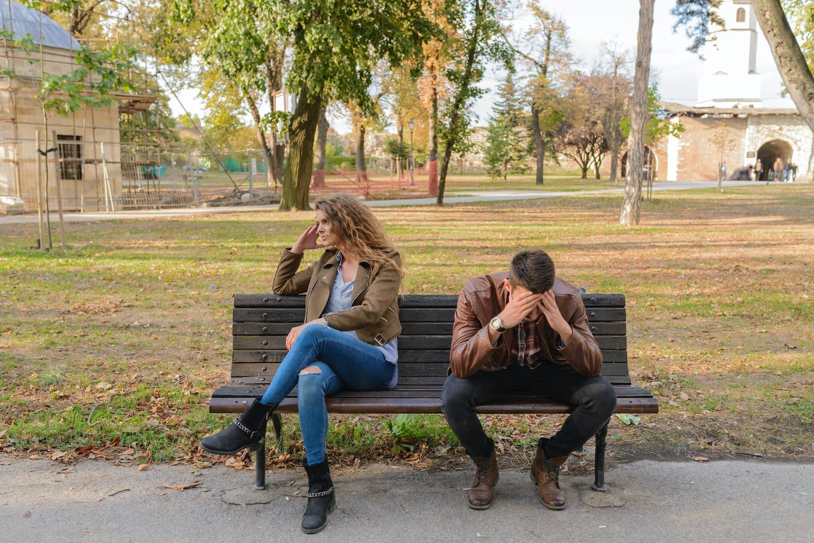 vrouw en man maken ruzie op een bankje in een park