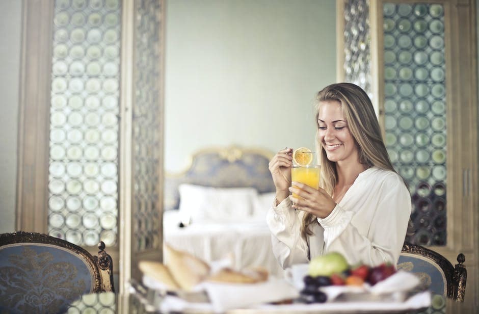 Vrolijke vrouw die geniet van het ontbijt in de ochtend