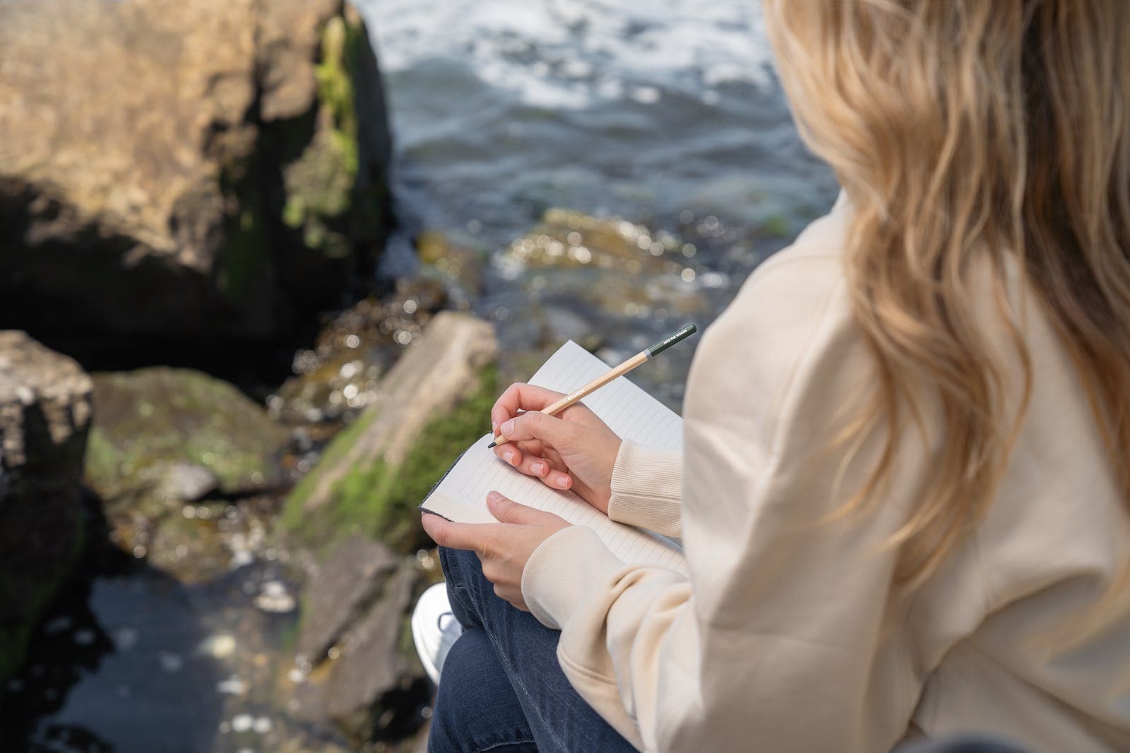 Vrouw die aan het schrijven is bij een beekje