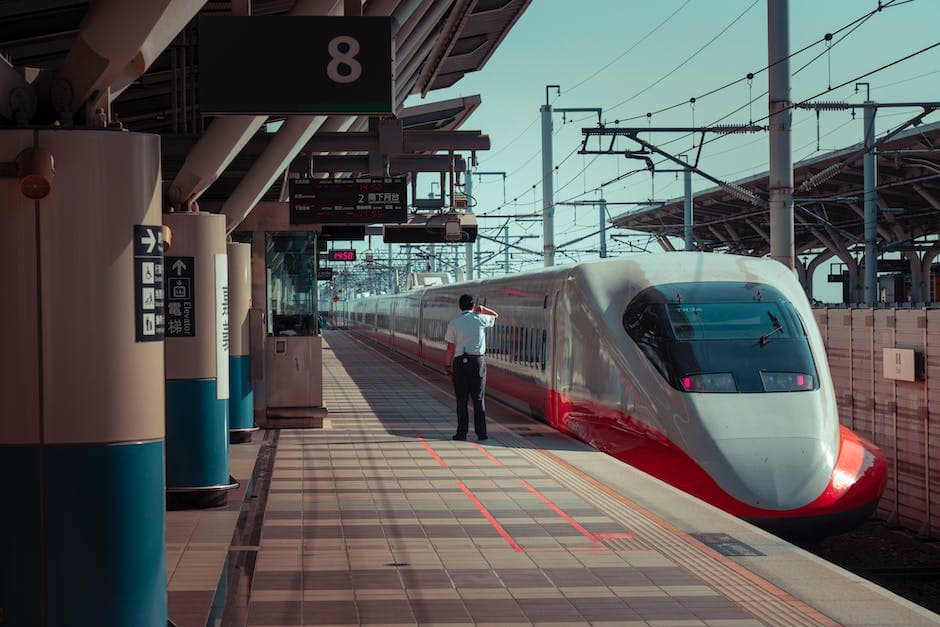 Anonieme man die op het treinstation staat dicht bij een moderne trein