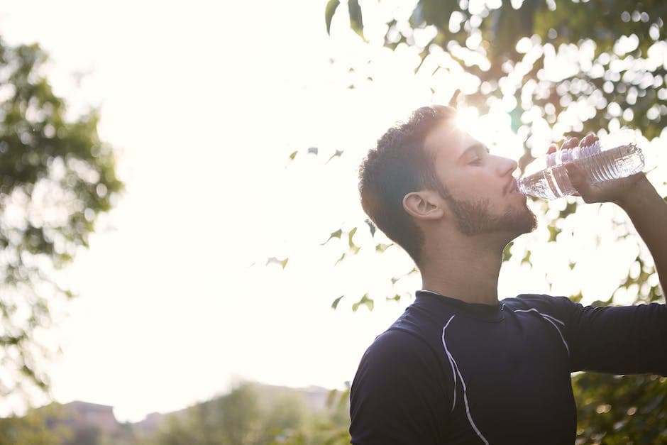 Man in zwart crewneck-shirt drinkt water