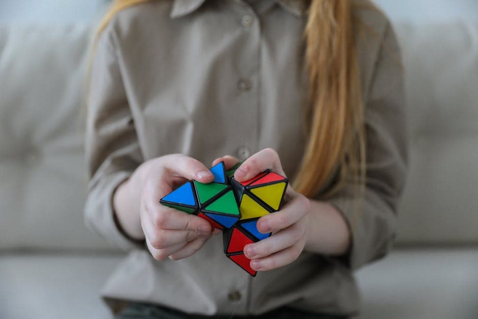 Anoniem meisje dat een kleurrijke puzzel met driehoeken demonstreert en oplost in soft focus