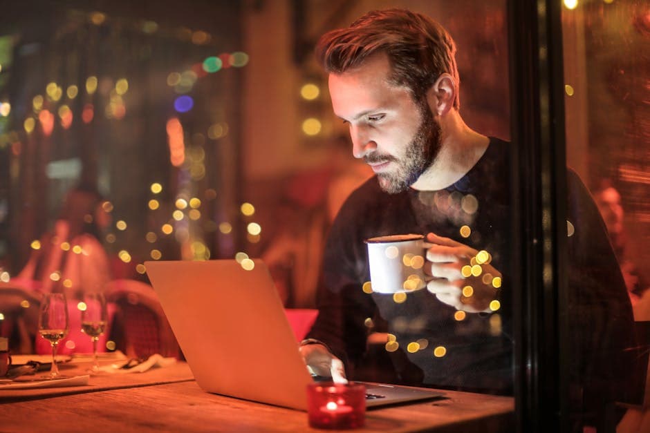 Man met mok voor laptop
