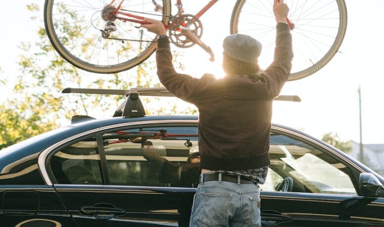 Man die fiets op zijn auto zet