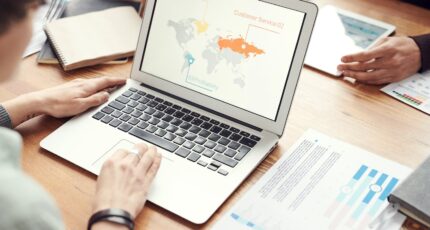 iemand gebruikt een laptop en bekijkt wereldkaart voor internationale samenwerkingen