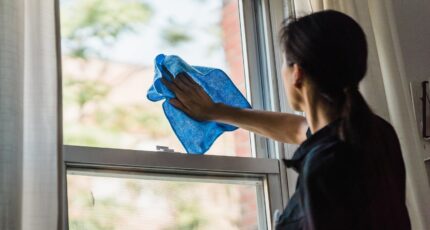 Vrouw in zwart shirt die de ramen afneemt