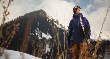 Man met snowboard die in het sneeuwachtig gebied loopt