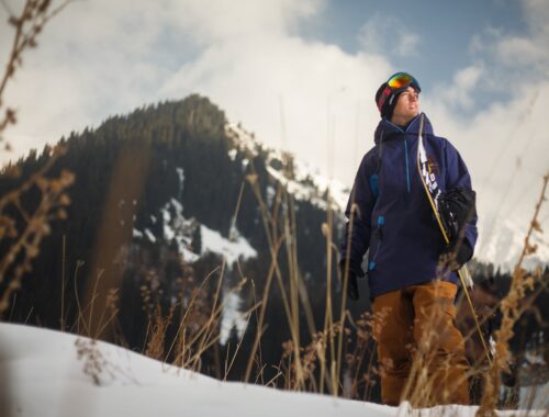 Man met snowboard die in het sneeuwachtig gebied loopt