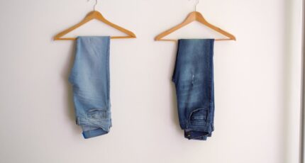 twee jeans aan een kleerhanger, lichtblauw en donkerblauw