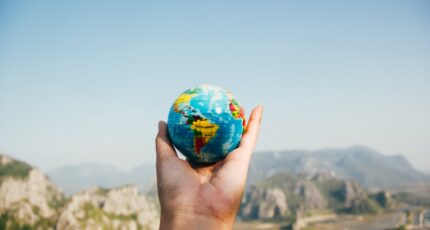 iemand houdt een kleine wereldbol in de hand