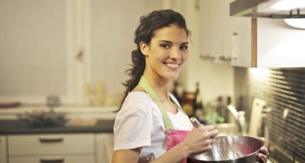 Zijkant van een vrouw die iets aan het maken is, mogelijk oliebollen