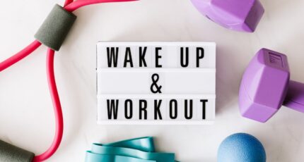 bordje met 'wake up & workout' omringd met sportspullen