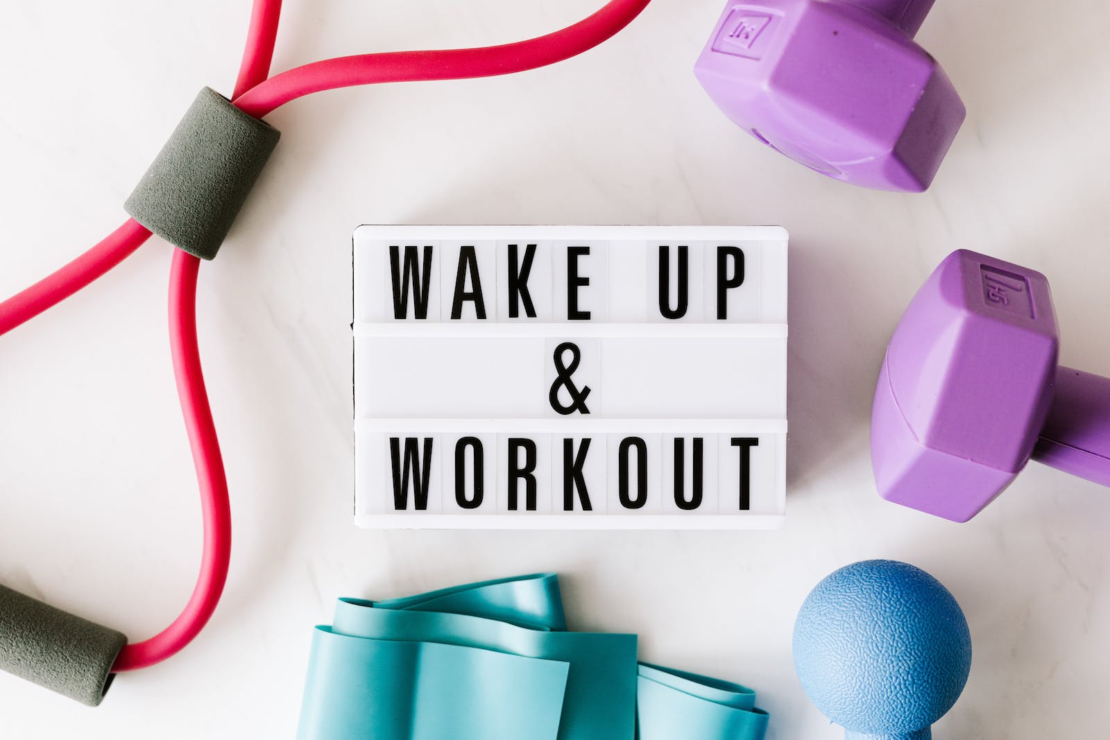 bordje met 'wake up & workout' omringd met sportspullen