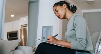 een mevrouw die zich concentreert op een oefening van een cursus zakelijk schrijven
