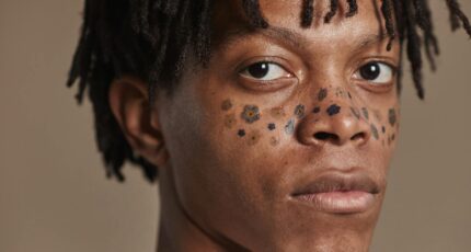 een man met tattoo's van bloemen op de wangen