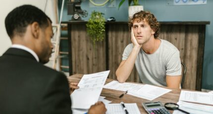 Een man zit bij de schuldsaneerder