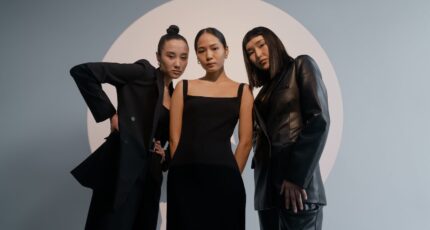 drie vrouwen poseren in zwarte kleding