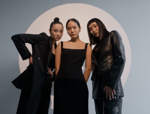 drie vrouwen poseren in zwarte kleding