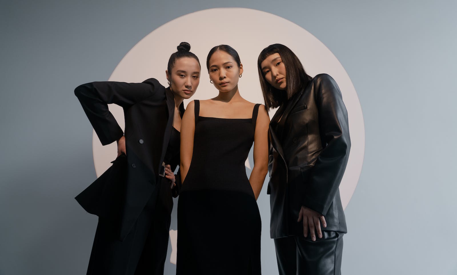 drie vrouwen poseren in zwarte kleding