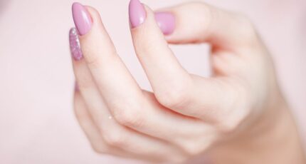 De hand van een persoon met gelnagellak op