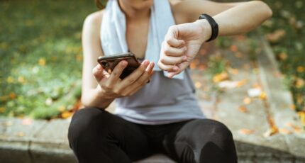 een vrouw kijkt tijdens het sporten op een app die het sporten trackt
