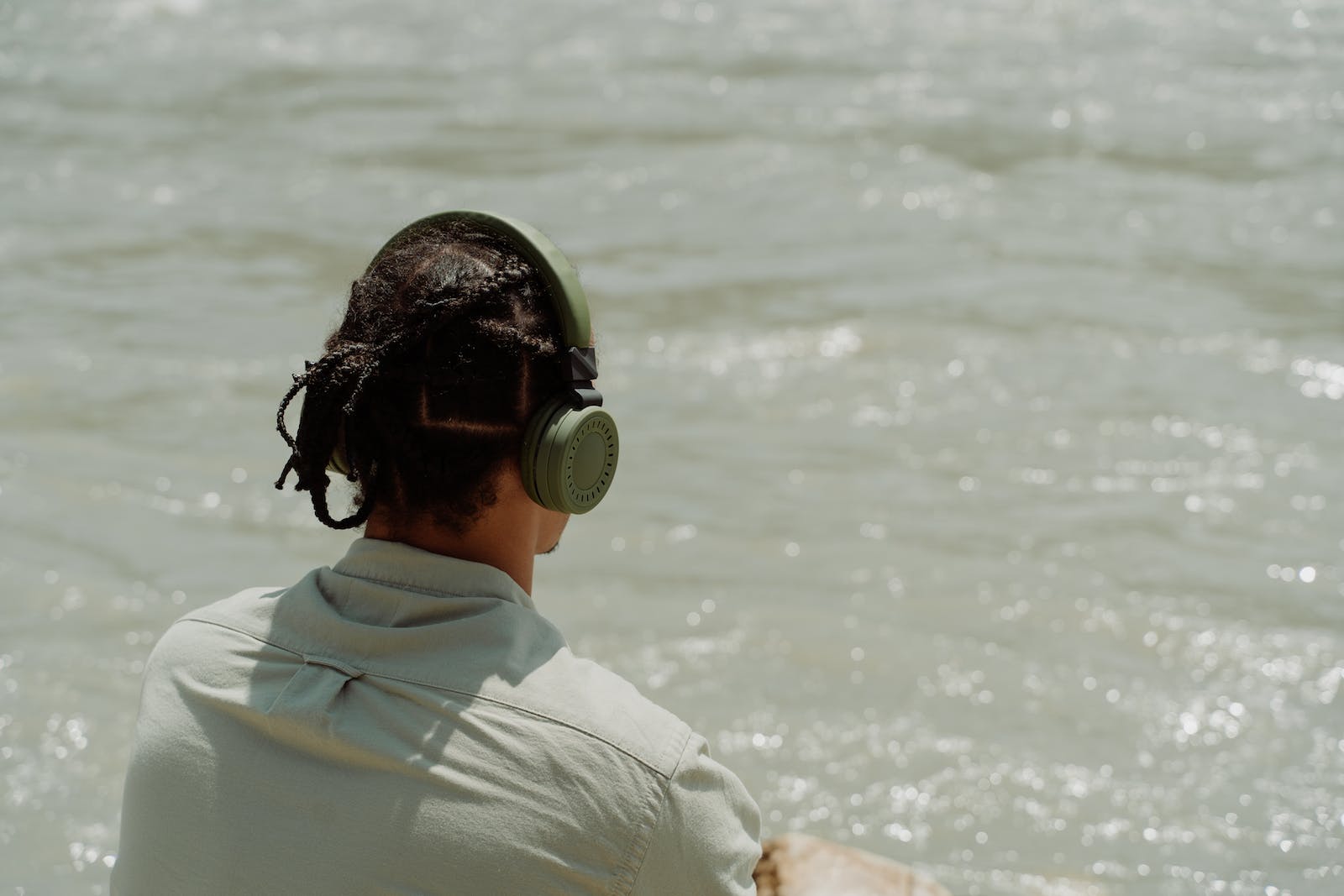 Jongen luistert muziek aan zee via een draadloze koptelefoon