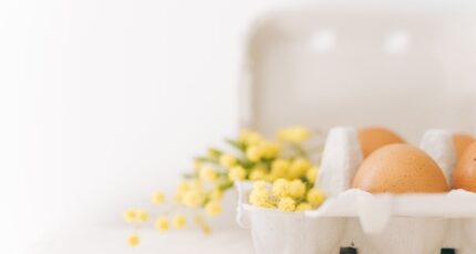 Bruine eieren en gele bloemen op een karton