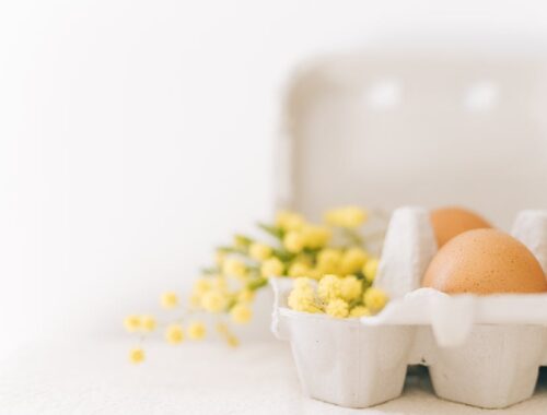 Bruine eieren en gele bloemen op een karton