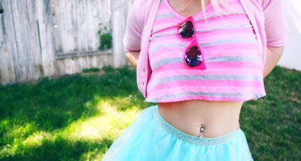 Een vrouw in roze gestreept shirt en blauwe rok