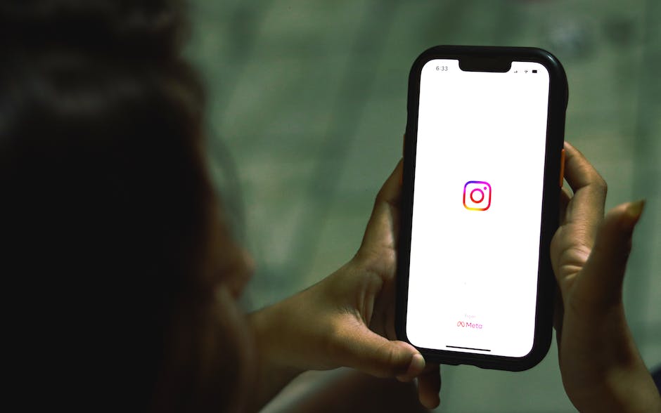 Hand houdt een smartphone vast met het Instagram-icoon op het scherm. iPhone met een logo van een sociale media-app.