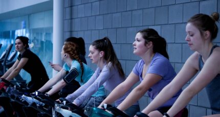Groep vrouwen vormt een spinning les op een fitness fiets