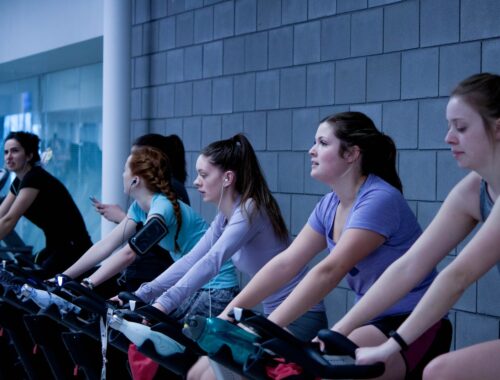 Groep vrouwen vormt een spinning les op een fitness fiets