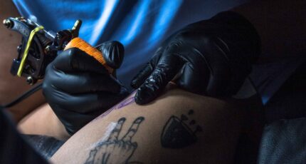 Close-up weergave van een persoon die een andere persoon tatoeëert