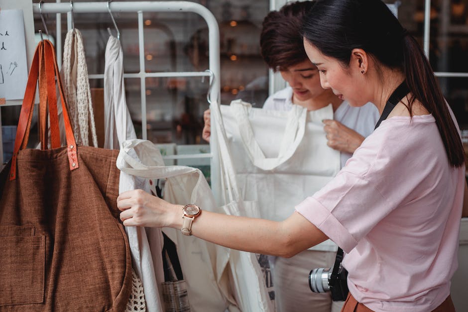 Modieuze jonge Aziatische vrouwen kiezen katoenen tassen in een modewinkel