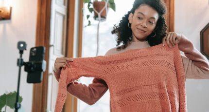 een vrouw neemt een vlog op waarin ze een trui laat zien