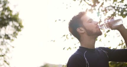 Man in zwart crewneck-shirt drinkt water