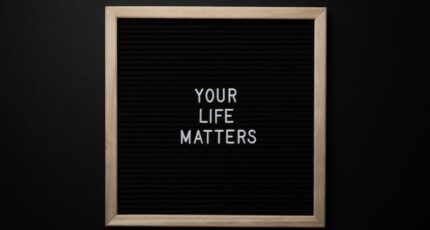 Schoolbord met de inscriptie JE LEVEN DOET ER TOE op een zwarte achtergrond