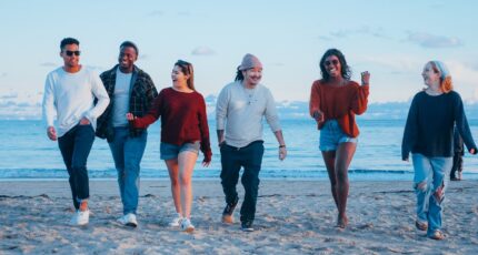 een groep vrienden loopt over het strand