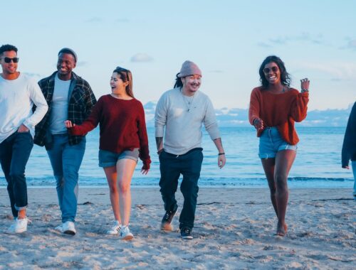 een groep vrienden loopt over het strand