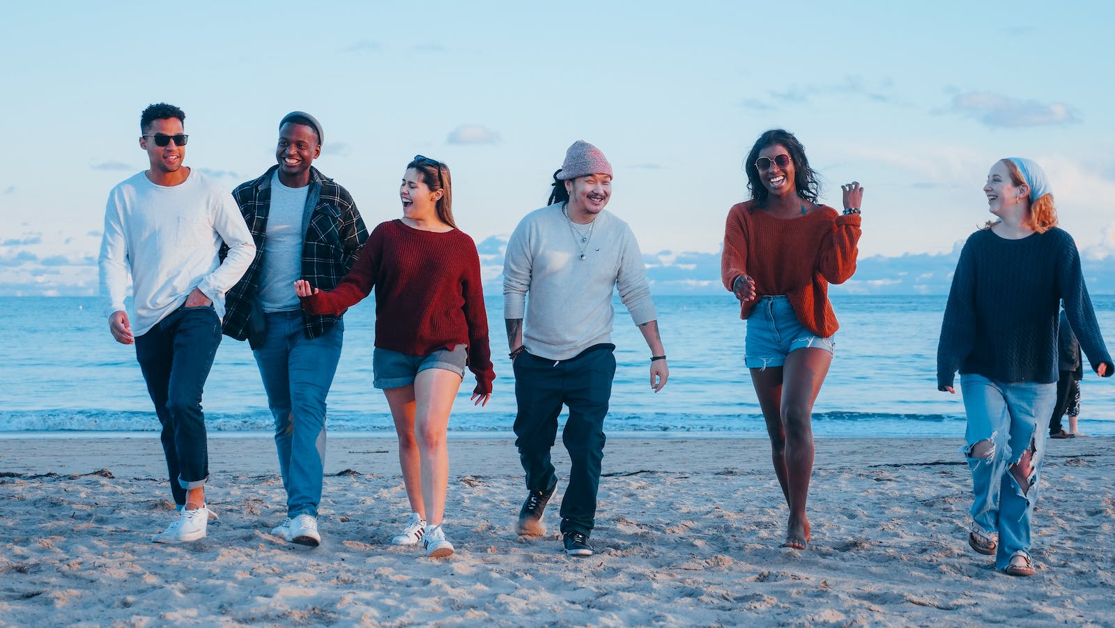 een groep vrienden loopt over het strand