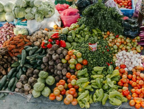 Verschillende groenten zoals paprika, bieten, kool, tomaten, greens, aardappel, courgette en wortel op de markt vanuit een vogelperspectief