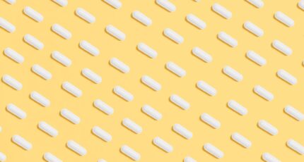 witte pillen tegen een gele achtergrond