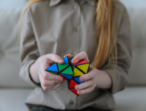 Anoniem meisje dat een kleurrijke puzzel met driehoeken demonstreert en oplost in soft focus