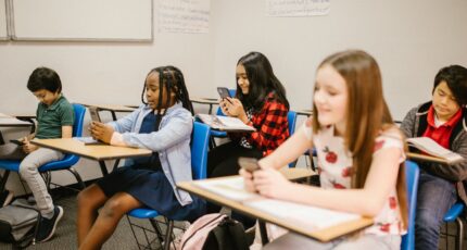 een klas met kinderen die een mobiel vasthouden