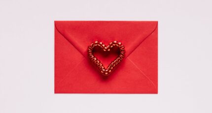 Colorful gift envelope with heart on pink background