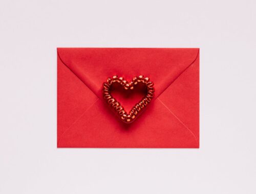 Colorful gift envelope with heart on pink background