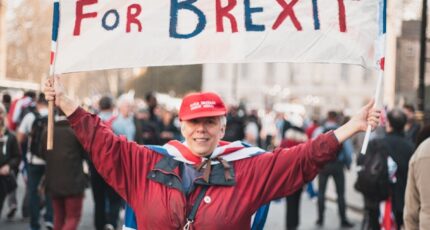 A Woman in Red Jacket Holding a Banner for britain, for brexit