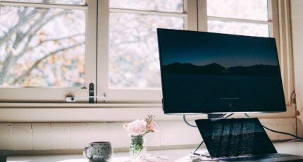 Een thuiswerkplek met laptop en scherm