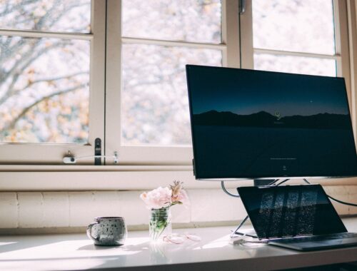 Een thuiswerkplek met laptop en scherm